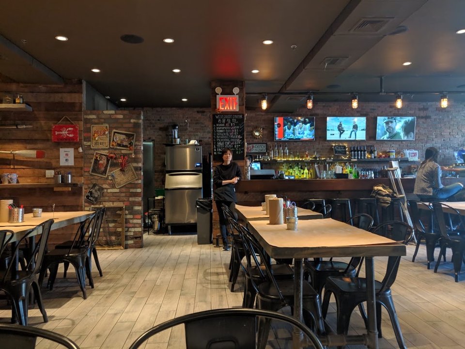 Warm restaurant interior with seating and exposed brick.